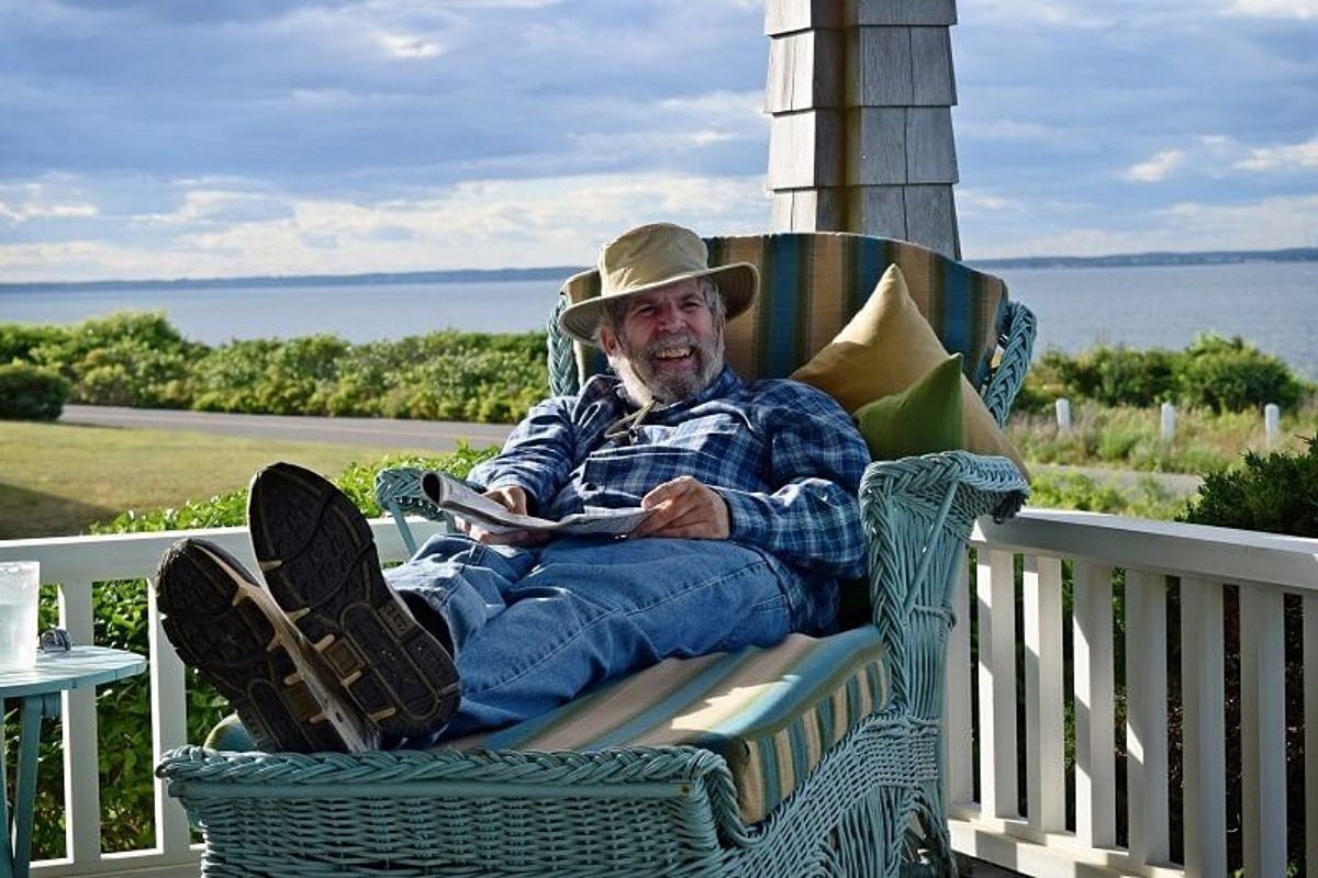 Older man resting on a chair on a porch, representing retirement planning