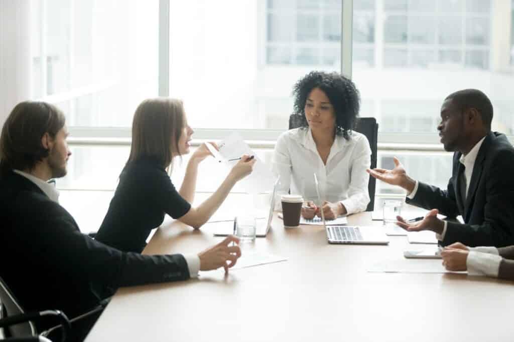 young business people sitting at a conference table; representing small business using SIMPLE IRA