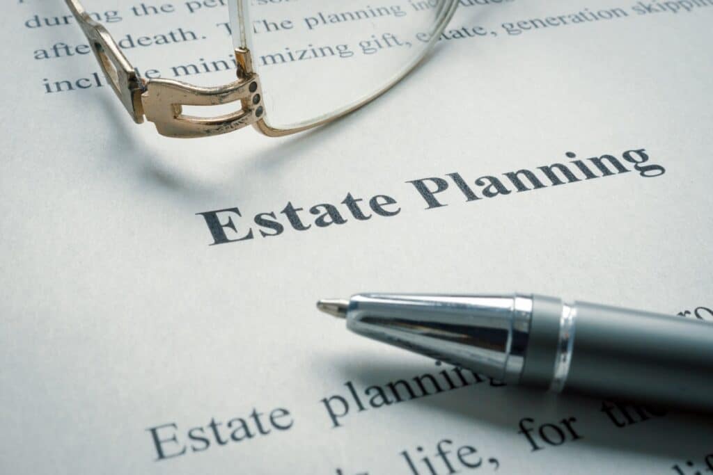 Paper page with Estate Planning printed at the top with eye glasses and a pen.